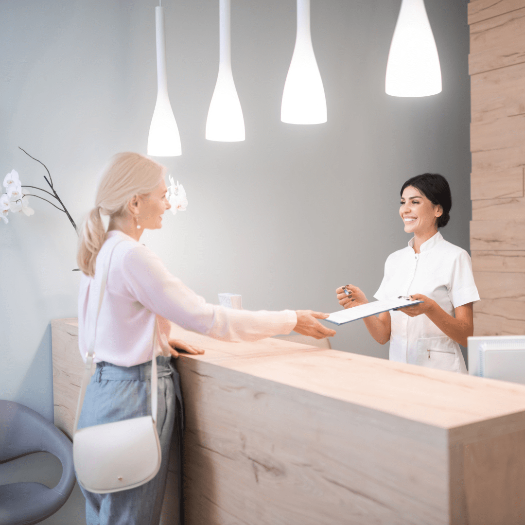 your first visit - welcoming into clinic, reception team welcoming client for local business discount